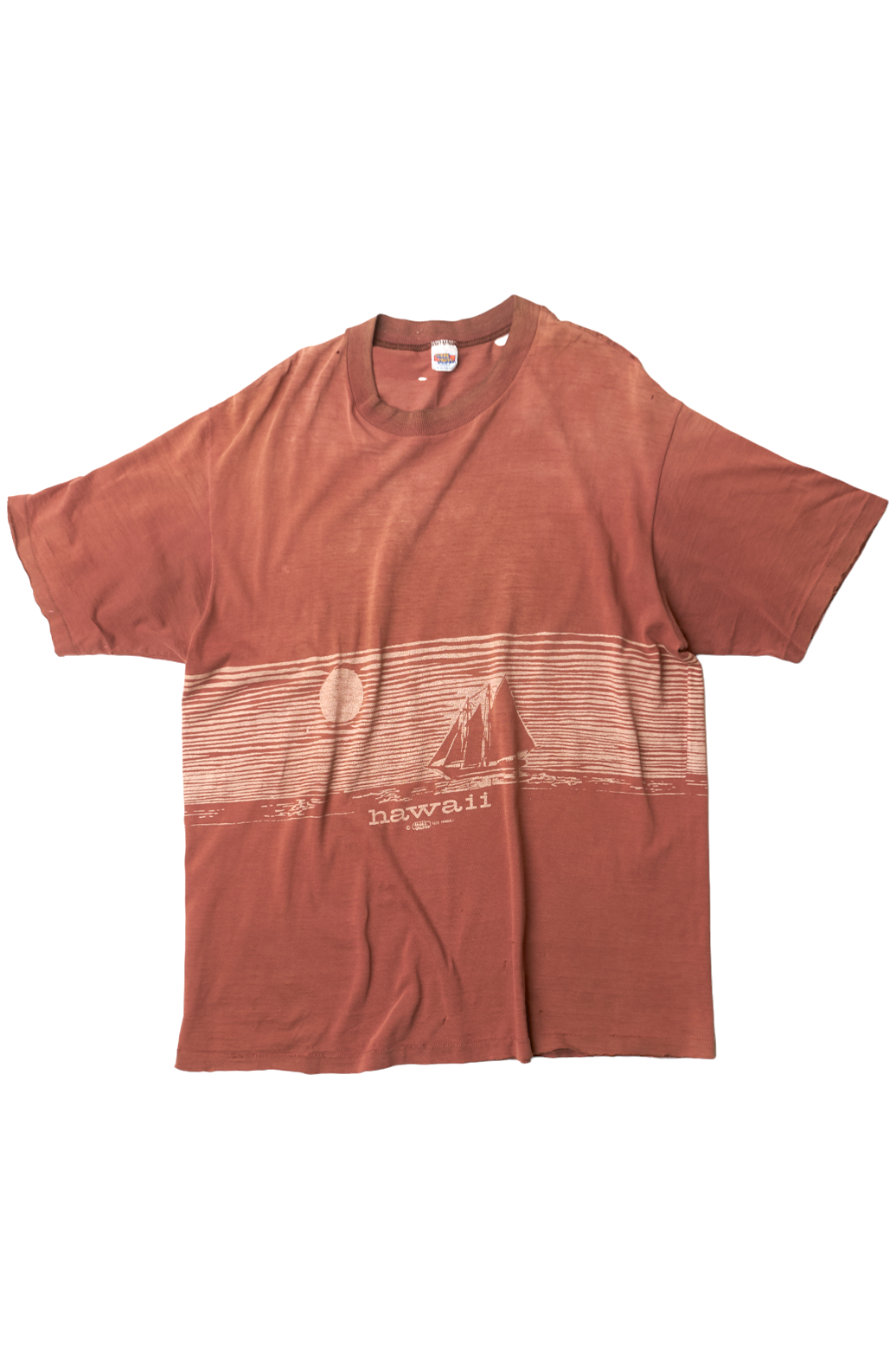 A vintage brown t-shirt with a graphic print, showing signs of wear such as fading at the shoulders and fraying edges.