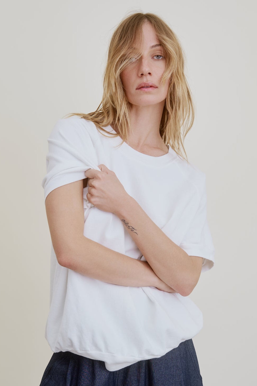 Woman wearing a white t-shirt against a plain background